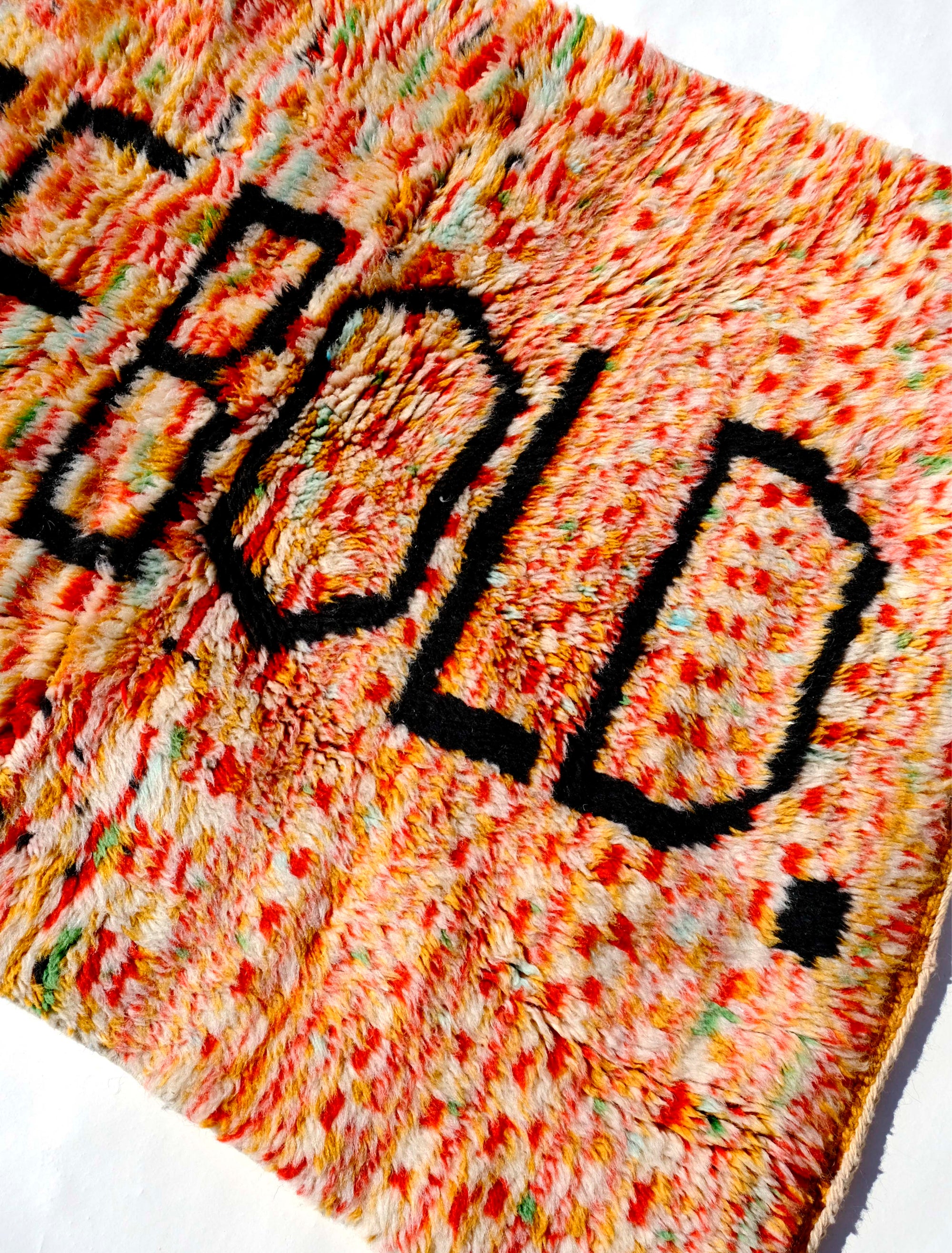 Elevate your space with the 'Tangerine Radiance Rug.' Handmade in the Atlas Mountains, this vibrant rug features a unique checkerboard pattern in warm tangerine tones. The focal point, proclaiming 'BE BOLD' in black letters, adds a touch of inspiration. With a fuzzy texture and meticulous craftsmanship, this rug brings warmth and positive energy to any room.  Size: 80 x 120cm / 31 x 47in 