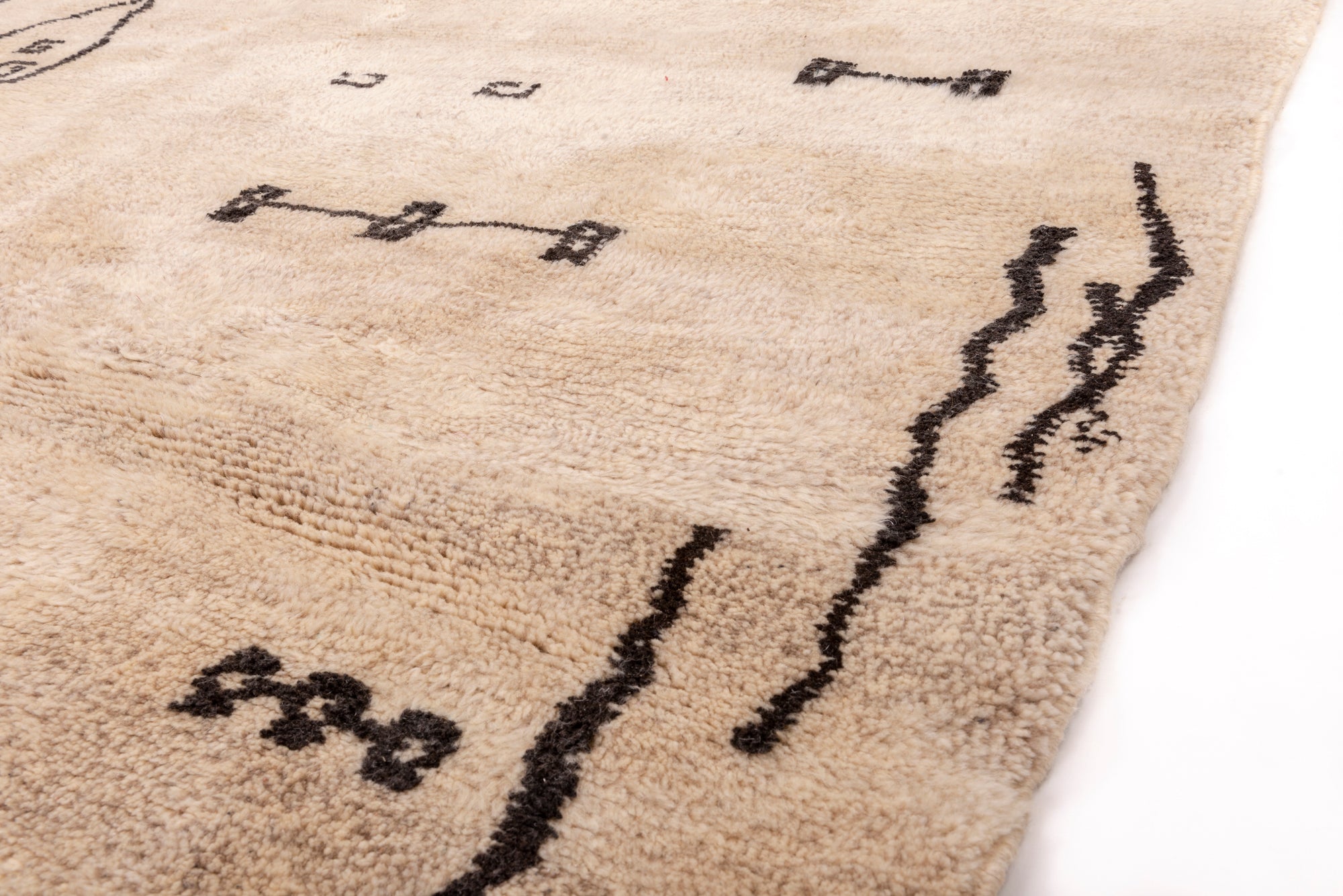 Transform your living space with our 'Ivory Homestead Berber Rug.' Crafted with an ivory base and adorned with abstract motifs reminiscent of houses and lines, this wool Berber rug brings a touch of cozy charm to your home decor.
